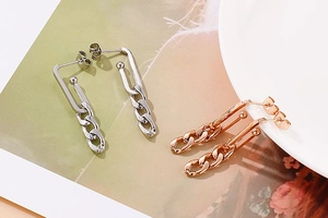 Detail view of titanium steel chain earrings in silver and rose gold finishes