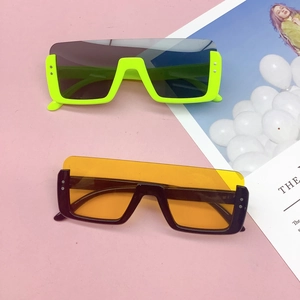 Flat lay of square flat-top kids sunglasses in neon green and black with tinted lenses