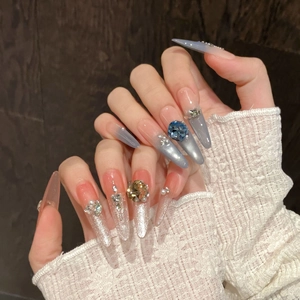 Long almond press-on nails with blue grey cat-eye gradient and luxury rhinestone accents