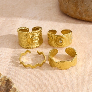 Set of four gold stainless steel rings featuring sun and star motifs with crystal accents