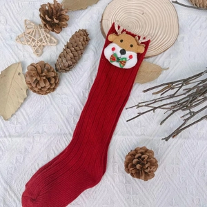 Close-up of red Christmas stockings featuring 3D reindeer doll and ribbed knit texture