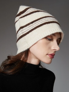 Detailed close-up of beige knit beanie featuring brown stripes and soft wool texture