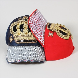 Detail of denim baseball caps with rhinestone crown patches and pearl embellishments