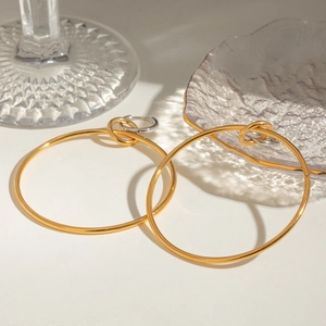 Boucles d'oreilles créoles bicolores or et argent sur décor en verre élégant et épuré