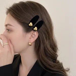 Elegante fermaglio per capelli a cuore dorato con velluto nero su capelli castani