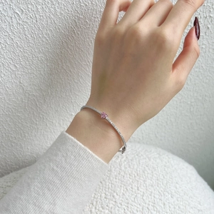 Close-up of S925 silver bracelet featuring pink heart gemstone and sparkling pavé diamonds