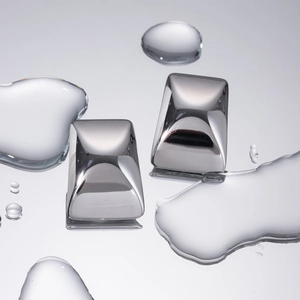 Polished silver stainless steel pillow-shaped stud earrings on a reflective water surface