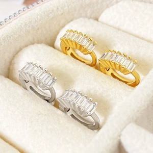Gold and silver huggie hoop earrings with rectangular cubic zirconia set in jewelry box