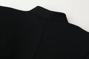 Detailed close-up of the back neckline and shoulder stitching on a black blazer