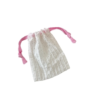 White drawstring fabric pouch with black polka dots and pink cotton rope closure