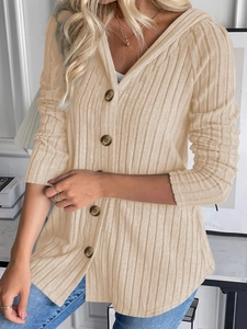 Dettaglio della trama a costine beige del cardigan con cappuccio e bottoni marroni