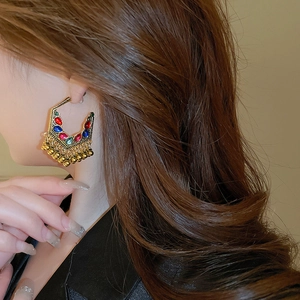 Macro side view of ethnic bohemian teardrop fringe earrings with pearls on model
