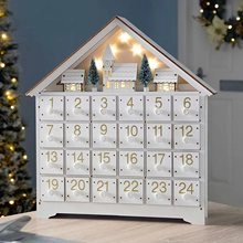 Detailed view of white wooden advent calendar with 24 drawers and LED glowing scene