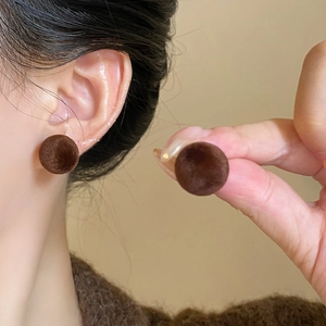 Detailed view of dark brown flocked round stud earrings with velvet texture for women