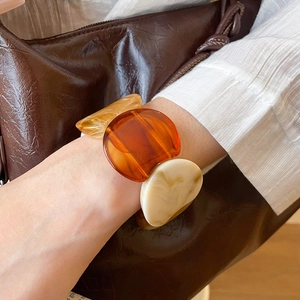 Detail of amber and marble resin chunky bracelet on model with vintage aesthetic
