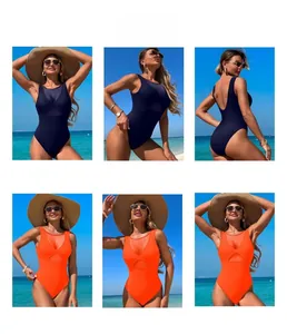 Detail of navy and orange swimsuit with mesh splicing and cutout design on a beach