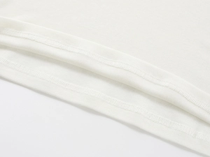 Close-up of double-needle hem on a white tencel wool blend knit V-neck t-shirt