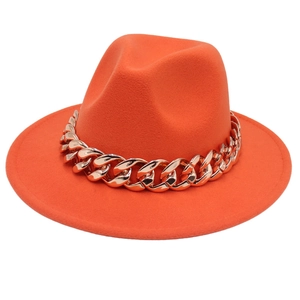 Close-up of orange wool fedora hat featuring a chunky gold metal chain decoration
