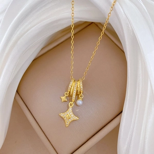 Close-up of gold titanium necklace featuring a sparkling star pendant and pearl detail
