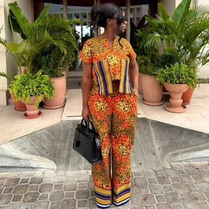 Women's two-piece set featuring orange abstract print V-neck top and wide-leg pants