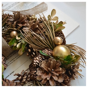Close-up of vintage Christmas pinecone wreath with golden ornaments and branch details