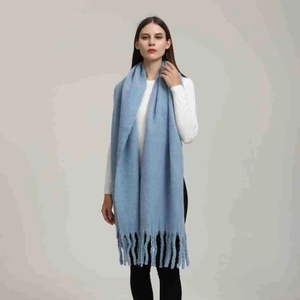 Dettaglio sciarpa celeste in finto cashmere con lunghe frange e trama a maglia morbida