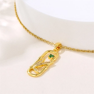 Gold leaf zircon necklace with hollow rectangular pendant and green gemstone detail