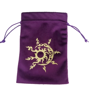 Detail of purple velvet drawstring pouch with golden sun and moon totem print