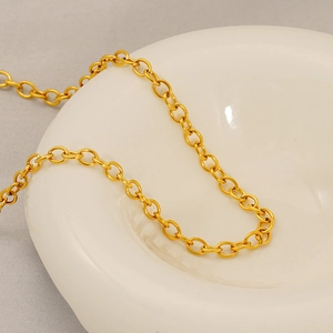 Minimalist gold stainless steel O-chain necklace displayed on a white ceramic plate