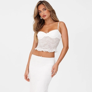 Close-up of elegant white lace corset top and matching slim fit skirt with lace trim
