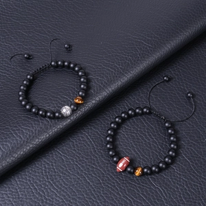 Close-up of 8mm matte tiger eye bead bracelets with silver basketball and brown rugby charms