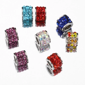 Colorful stainless steel spacer beads with crystal rhinestones on reflective surface