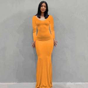 Detalle de vestido largo naranja de manga larga ajustado con diseño de dobladillo sirena