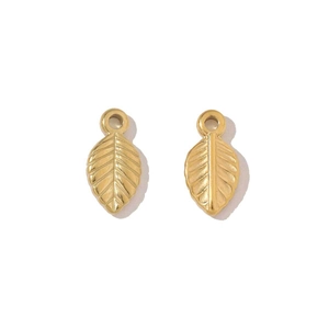 Detailed view of two gold leaf-shaped stainless steel charms with fine vein textures