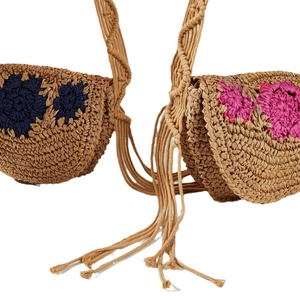Handmade straw crossbody bags with floral embroidery and tassel details on white background