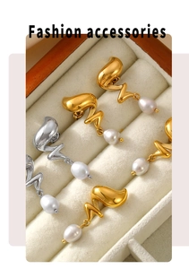 Dettaglio di orecchini a spirale in oro e argento con perle d'acqua dolce