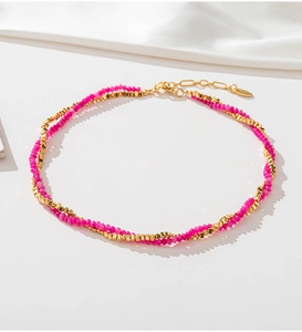 Macro detail of double-layer beaded necklace with pink stones and gold chain link