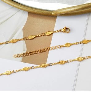 Detailed macro view of golden textured oval links with lobster clasp and extender chain
