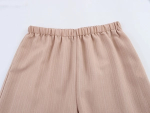 Vue détaillée de la taille élastique et du tissu plissé sur le pantalon de vacances ample