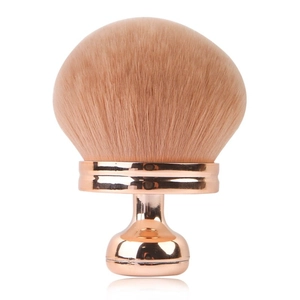 Close-up of rose gold mushroom makeup brush with soft dense pink synthetic bristles