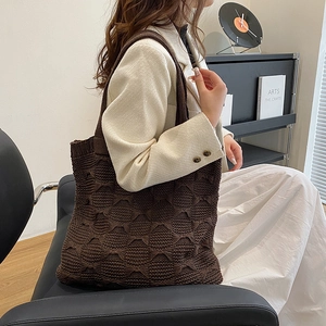 Detailed macro of dark brown knitted tote bag featuring a textured diamond stitch pattern