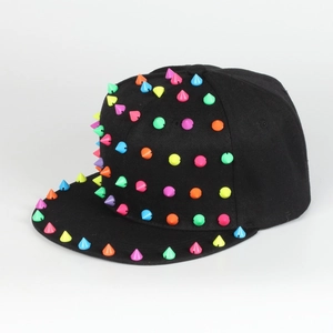 Detail der bunten Punk-Nieten auf einer schwarzen Flatbrim Hip-Hop Mütze mit Spikes