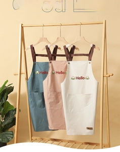 Three waterproof aprons in green pink and beige with H-shaped straps and front pockets