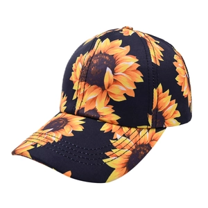 Detail of classic black baseball cap with vibrant yellow sunflower floral patterns