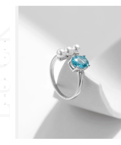 Detail of S925 silver ring with blue oval gemstone and three white pearls