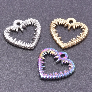 Macro detail of three heart-shaped pendants in silver gold and rainbow stainless steel