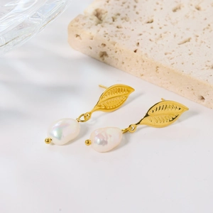 Golden hollow leaf earrings with natural baroque pearls in a minimalist elegant setting