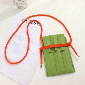 Detail of green knitted phone bag with vertical ribbed texture and orange shoulder strap