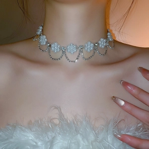 Macro shot of a pearl flower necklace with crystals and elegant tassel detailing