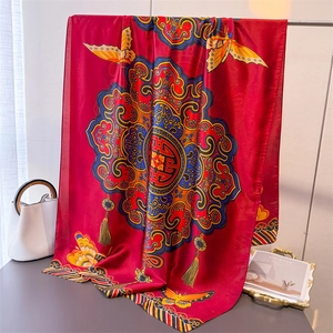 Châle en soie rouge à imprimé papillon et motifs floraux suspendu à un support métal